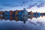 Fototapeta Tęcza - Tranquil dawn at colorful wooden houses in a small marina in Groningen.  Living at the waterfront in Holland.