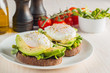© xander21 - Avocado toast, cherry tomato and poached eggs on wooden background. Breakfast with vegetarian food, healthy diet concept.