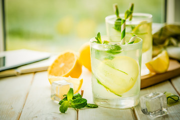 Summer lemonade in glasses in front of window, copy space