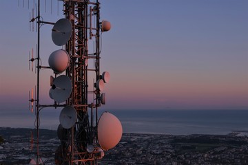 Telecommunications tower, antenna and satellite dish and aerial view of the city as background. Copy space