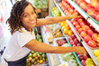Pretty smiling Black woman working at fruit department at grocery store