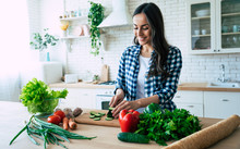 Beautiful Young Woman Is Preparing Vegetable Salad In The Kitchen. Healthy Food. Vegan Salad. Diet. Dieting Concept. Healthy Lifestyle. Cooking At Home. Prepare Food. Cutting Ingredients On Table
