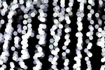 Abstract bokeh of white city lights on black background. defocused and blurred many round light