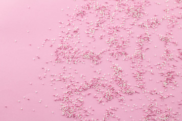 Pink and white sprinkles on pink background - Cake topping pearly pink sprinkles top view image