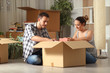 © Antonioguillem - Serious couple boxing belongings on the floor moving house
