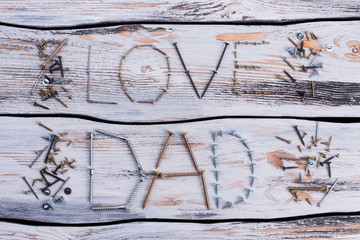 Wall Mural - LOVE DAD inscription on wooden surface. Greeting card made of tools. Happy Fathers Day.