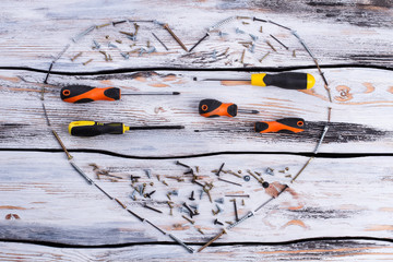 Wall Mural - Fathers Day composition on wooden background. Form of heart made from screws and screwdrivers. Fathers Day celebration.