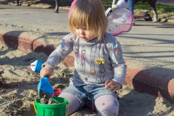 Beautiful little girl with fairy wings playing the sand