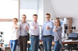 © Pixel-Shot - Group of young business people showing thumb-up gesture in office