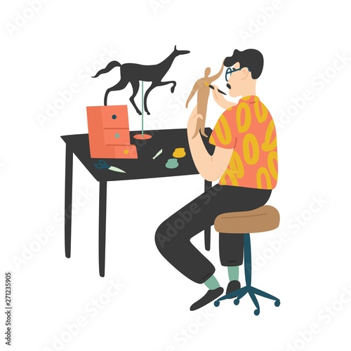 Young Man Sitting At Desk And Painting Handcrafted Miniature Paper