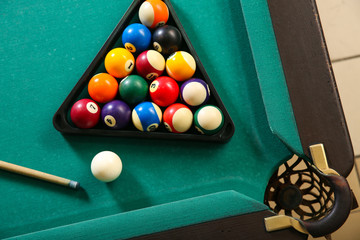 Canvas Print - Billiard balls in triangle rack with cue on table