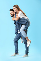 Poster - Stylish young couple in jeans clothes on color background