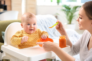 Mother feeding her little baby at home