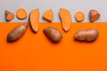 fresh sweet potatoes on color background