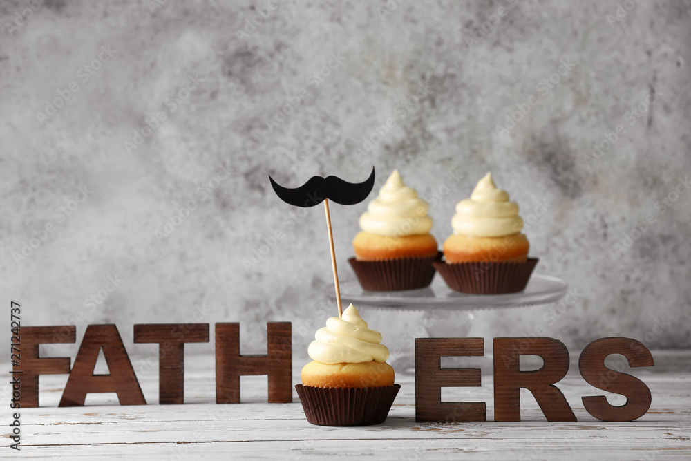Tasty cupcakes for Father's Day on white wooden table