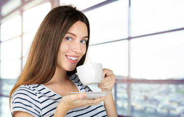 Canvas Print - Happy woman enjoying a warm cup of tea or coffee for breakfast