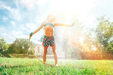 Cute Little Girl Refresh Herself From Garden Watering Hose