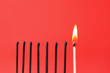 One Burning Match Among Burnt-out Ones On Color Background. Concept Of Uniqueness
