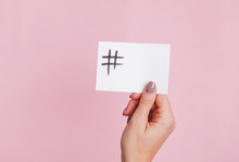 Woman's Hand Holding A Paper Card With Hashtag Symbol Drawn On It