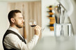 © Seventyfour - Side view portrait of professional sommelier holding wine glass during tasting session, copy space