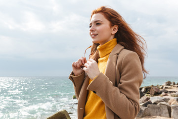 Poster - Beautiful young redheaded woman wearing coat