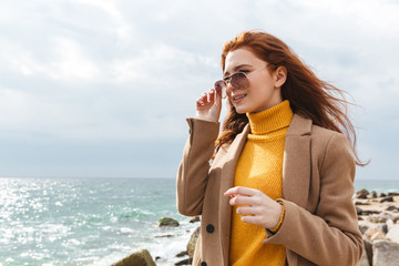 Poster - Beautiful young redheaded woman wearing coat