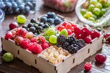 Colorful berries in wooden crate on the table.