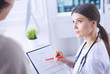 © lenets_tan - Beautiful female doctor explaining medical treatment to a patient