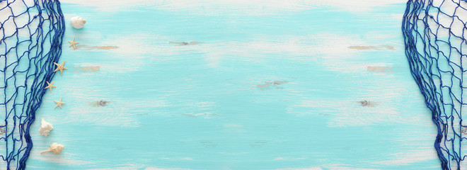 Top view of Fishnet on pastel blue wooden background. top view, flat lay. banner