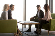 © fizkes - Business partners negotiate in conference room at briefing