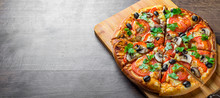 Sliced Pizza With Mozzarella Cheese, Tomatoes, Pepper, Olive, Mushrooms, Spices And Fresh Leaf. Italian Pizza On Wooden Table Background