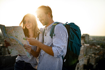 Poster - Happy couple on vacation sightseeing city with map