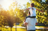 concept of father's day! happy family dad and child daughter back  in nature