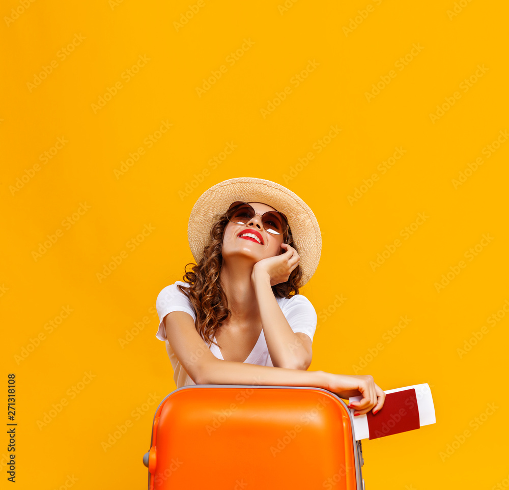 concept of travel. happy woman girl with suitcase and  passport on  yellow background. - obrazy, fototapety, plakaty 
