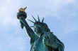 statue of liberty in new york with torch and tablet - close up from side with blue sky