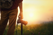 Travel Photographer. Man Traveler With Camera  At Sunset In Nature