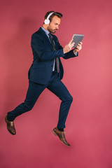 Wall Mural - Man listening to music jumping with tablet