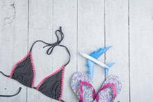Travel And Vacation Concept - Model Of Airplane, Fashion Swimsuit With Flip Flops In Polka Dots