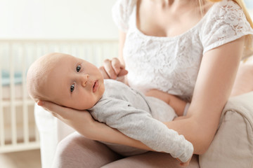 Wall Mural - Mother with her baby sitting in armchair at home