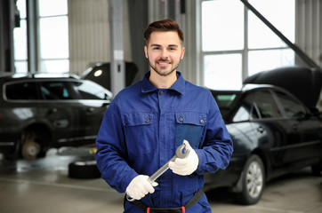 Canvas Print - Portrait of technician with wrench at automobile repair shop