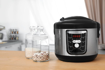 Poster - Jars with rice and beans near modern multi cooker on table in kitchen