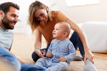 Wall Mural - Parents Sitting On Floor At Home Playing With Baby Son