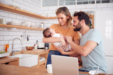 Wall Mural - Busy Family In Kitchen At Breakfast With Mother Caring For Baby Son