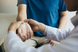 © wutzkoh - Physical therapist checks the patient wrist by pressing the wrist bone in clinic room.