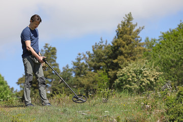 Man using metal detector to find old coins