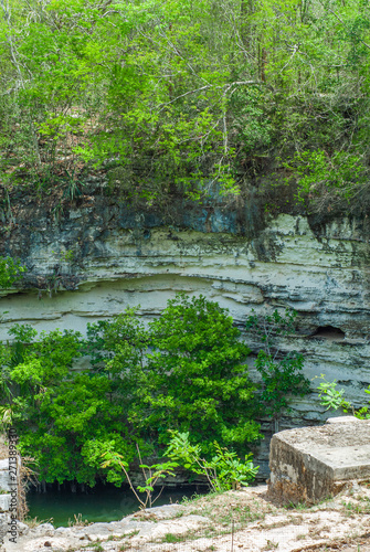 Fotomural Cenote at the bottom of the rocks, taken in the archaeological area of Chichen I