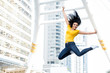 © Atstock Productions - Happy woman jumping with hands outstretched in the city