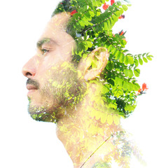 Double exposure of a young handsome man’s portrait blended with bright green leaves, showing the perfect beauty of nature's creation