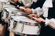 © Stanislav - A closeup of the hands of a drummer at a parade. Children's ensemble in white shirts. White new snare drum, white sticks. The concept of a military parade and march.