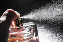 Spraying Perfume On Dark Background, Closeup